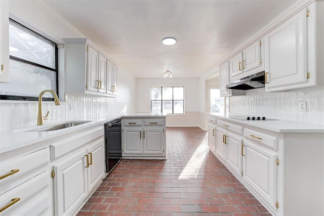 900 Woodbury Dr, Edmond, OK 73034 - kitchen with black appliances, under cabinet range hood, a peninsula, light countertops, and tasteful backsplash