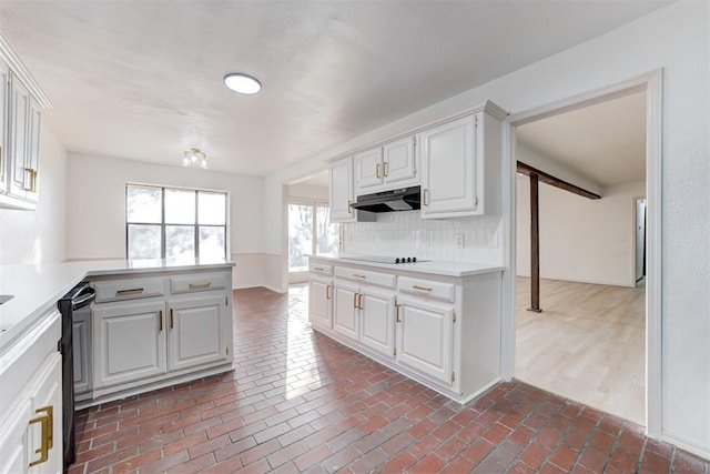 900 Woodbury Dr, Edmond, OK 73034 - kitchen featuring black appliances, under cabinet range hood, tasteful backsplash, light countertops, and a peninsula