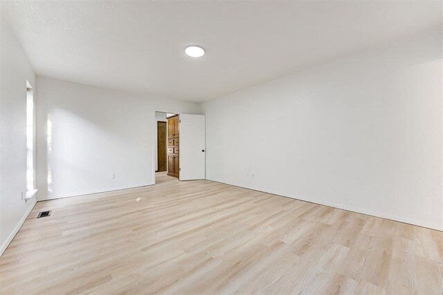 900 Woodbury Dr, Edmond, OK 73034 - spare room with light wood-type flooring and baseboards