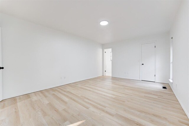 900 Woodbury Dr, Edmond, OK 73034 - spare room with light wood-style flooring and baseboards