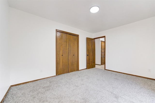 unfurnished bedroom with light carpet and a closet