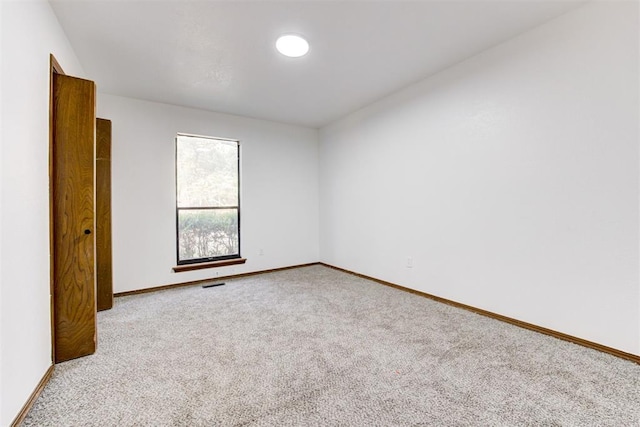 spare room featuring light colored carpet