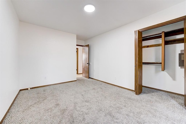 unfurnished bedroom featuring light carpet and a closet