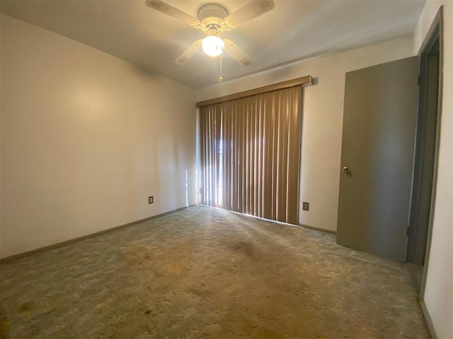 carpeted spare room featuring ceiling fan