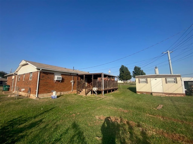 back of house featuring a lawn, a wall unit AC, a storage unit, and a deck