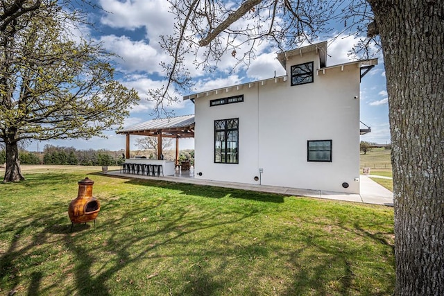 back of property with a lawn and an outdoor bar