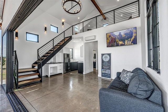 living room with beamed ceiling, a wall mounted air conditioner, high vaulted ceiling, and an inviting chandelier