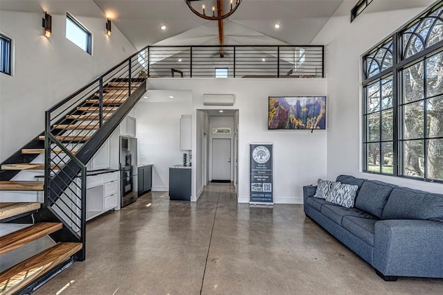 living room featuring a wealth of natural light, a towering ceiling, and concrete flooring