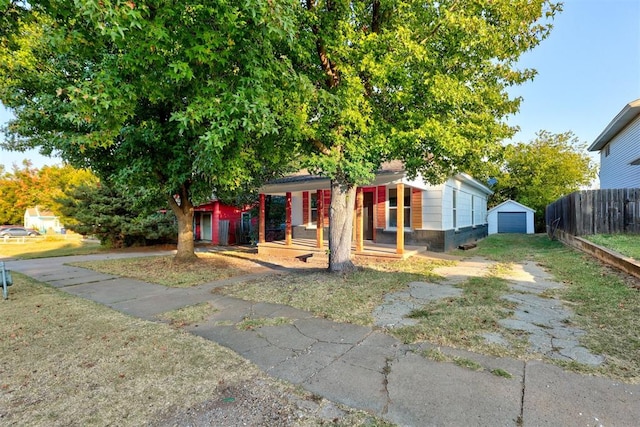 view of front facade featuring covered porch, a garage, and an outdoor structure