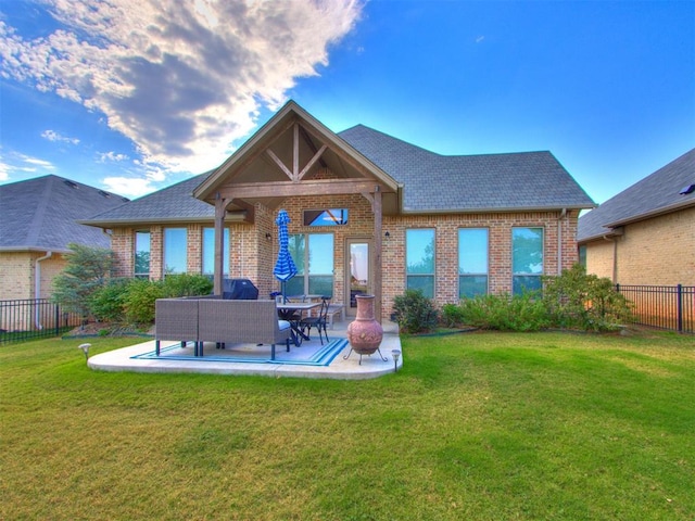 rear view of house featuring an outdoor hangout area, a patio area, and a lawn