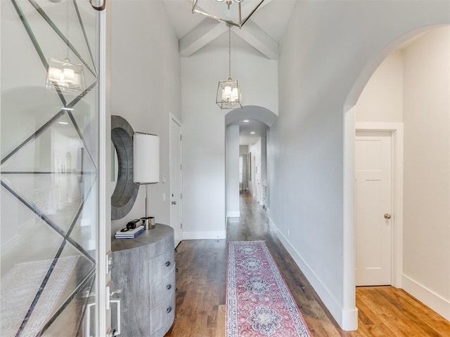 foyer entrance featuring beamed ceiling, hardwood / wood-style flooring, and high vaulted ceiling