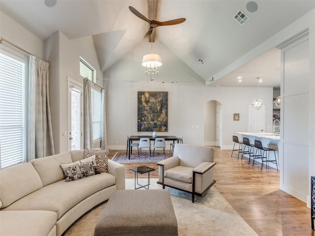 living room featuring ceiling fan with notable chandelier, lofted ceiling, sink, and light hardwood / wood-style flooring