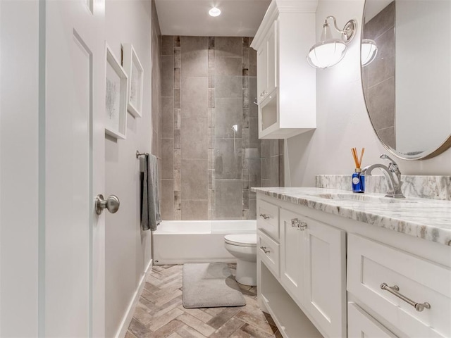 full bathroom with tiled shower / bath, vanity, and toilet