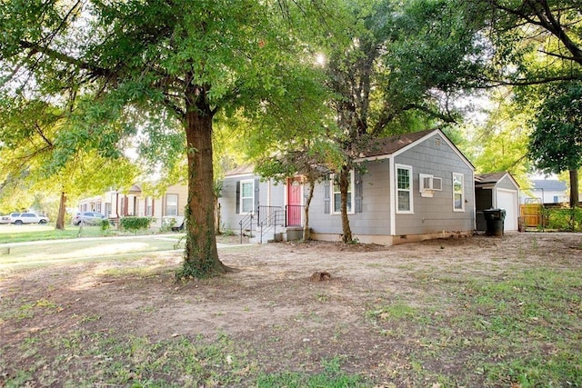 view of front of house featuring a wall mounted AC, an outbuilding, and a garage