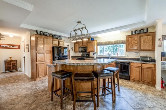 kitchen with pendant lighting, a center island, black appliances, and ornamental molding