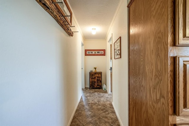 hall featuring crown molding, dark tile patterned floors, and a textured ceiling