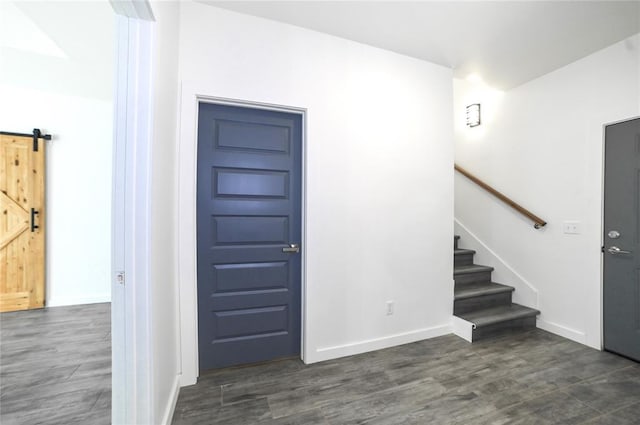 foyer with dark hardwood / wood-style floors and a barn door