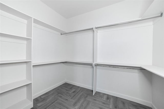 walk in closet featuring dark parquet flooring