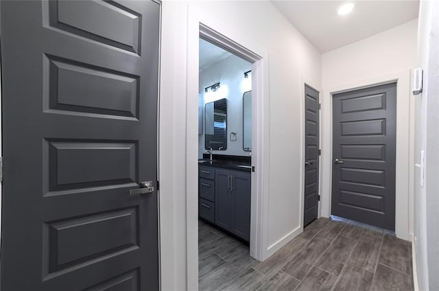 hall with dark wood-type flooring and sink