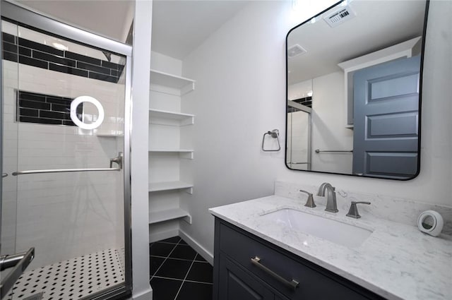 bathroom with tile patterned flooring, vanity, and walk in shower