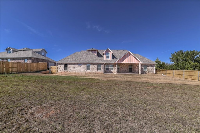 rear view of property featuring a lawn