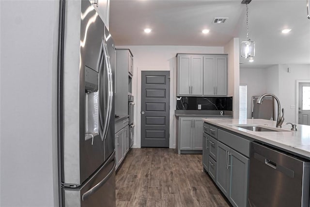 kitchen featuring gray cabinetry, sink, stainless steel appliances, and decorative light fixtures