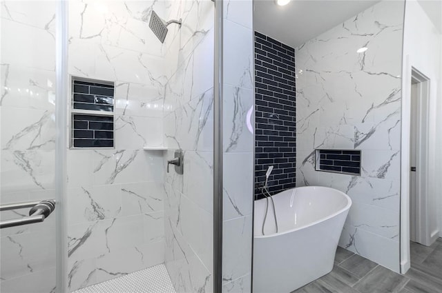 bathroom featuring shower with separate bathtub and tile walls