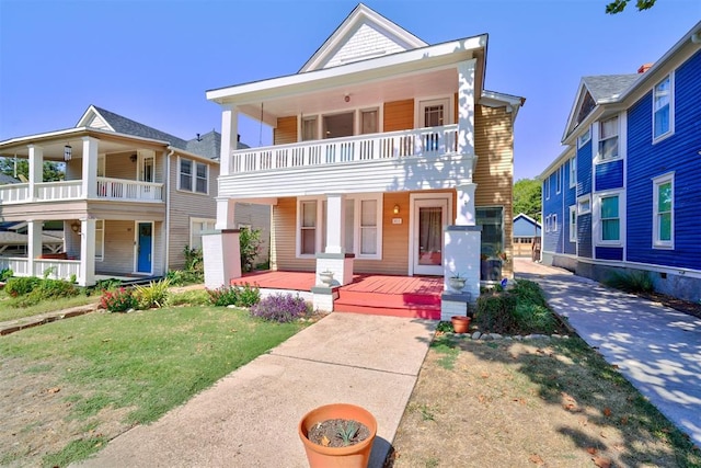 view of front of house featuring a balcony and a front lawn