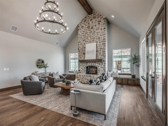 living area featuring visible vents, beam ceiling, a fireplace, wood finished floors, and high vaulted ceiling