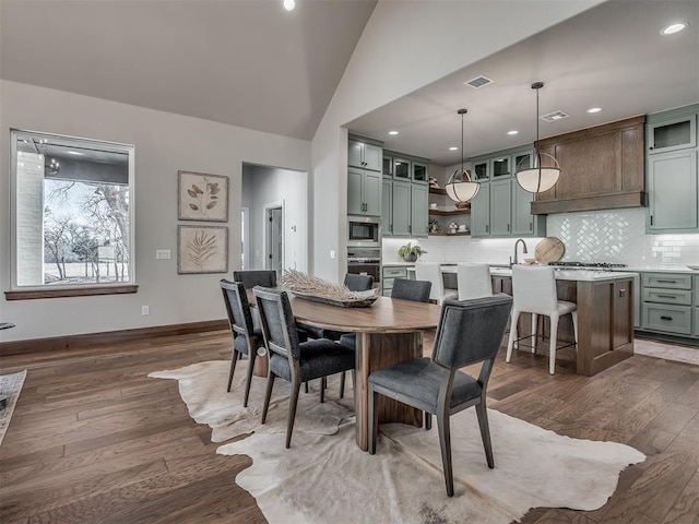 dining room with visible vents, baseboards, dark wood-type flooring, and lofted ceiling