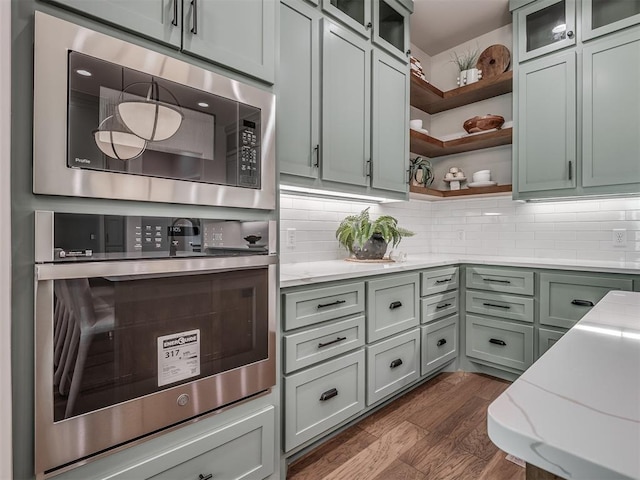 kitchen featuring tasteful backsplash, light stone countertops, dark wood finished floors, stainless steel appliances, and open shelves