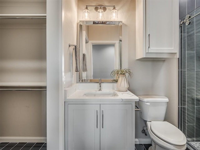 bathroom featuring tiled shower, baseboards, toilet, and vanity