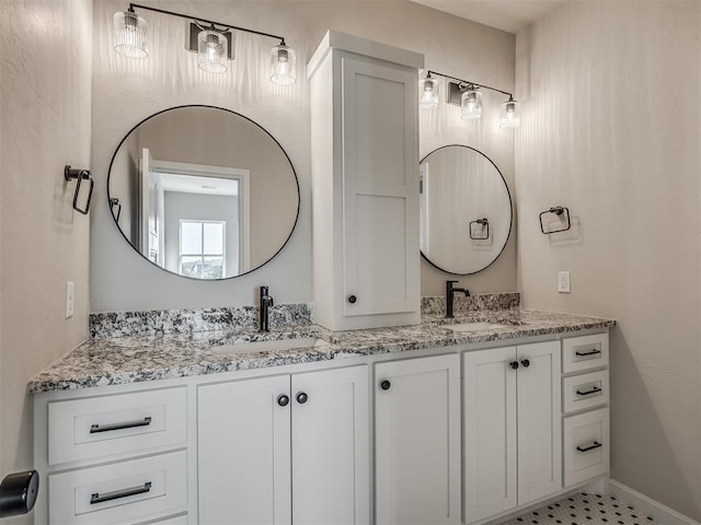 full bathroom with a sink, baseboards, and double vanity