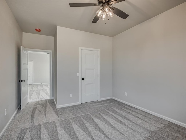 unfurnished bedroom with carpet flooring, baseboards, and ceiling fan