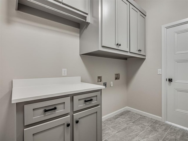 laundry area featuring washer hookup, cabinet space, and baseboards