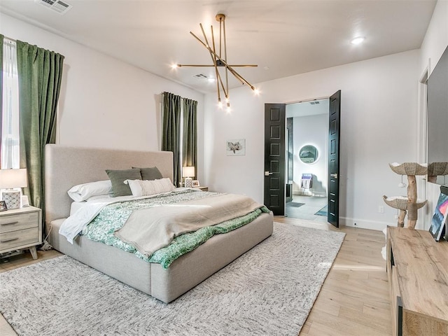 bedroom featuring a notable chandelier and light hardwood / wood-style floors