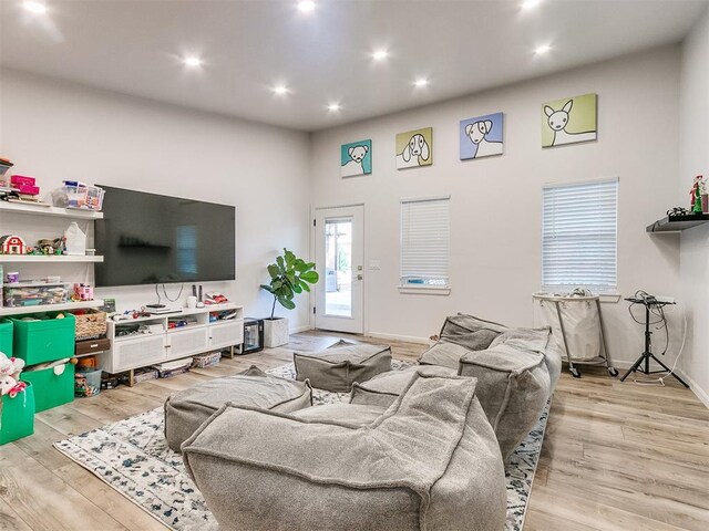 living room featuring light wood-type flooring and a high ceiling