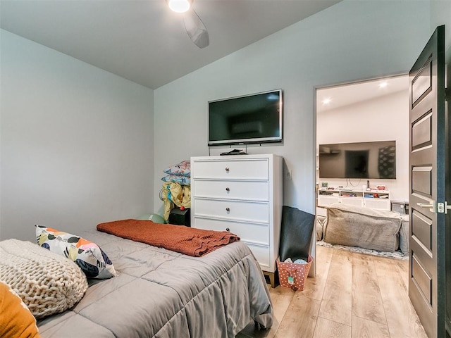 bedroom featuring light hardwood / wood-style flooring, vaulted ceiling, and ceiling fan