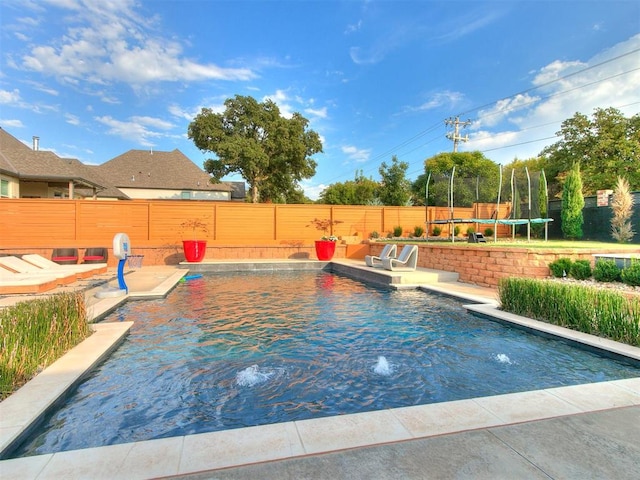 view of pool with pool water feature, a patio, and a trampoline