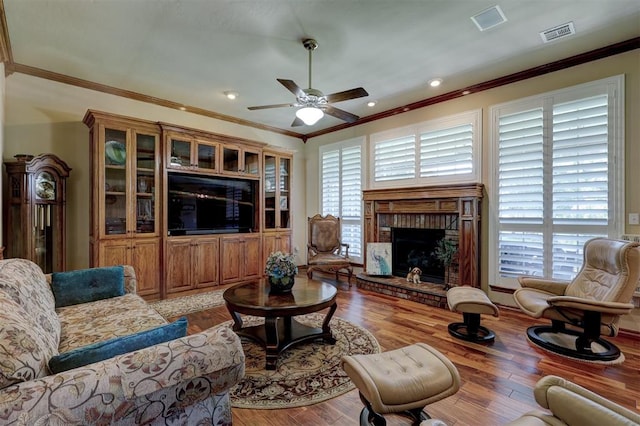 living room with ornamental molding, a wealth of natural light, and light hardwood / wood-style flooring