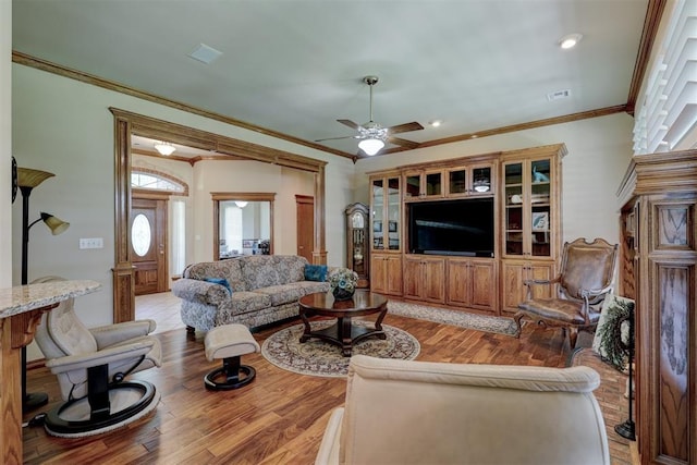 living room featuring light hardwood / wood-style floors, ceiling fan, and crown molding