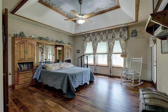 bedroom with a tray ceiling, ceiling fan, crown molding, and dark hardwood / wood-style floors