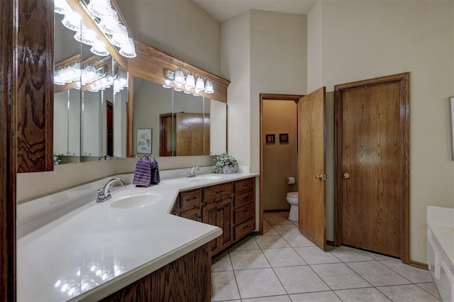 bathroom with tile patterned flooring, vanity, and toilet