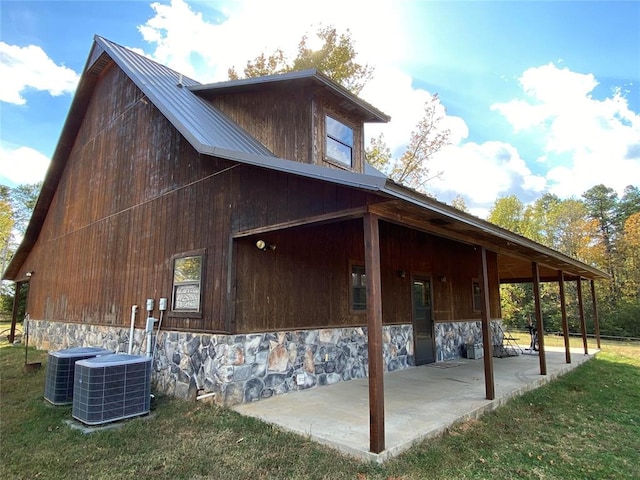 view of home's exterior featuring a lawn, a patio area, and cooling unit