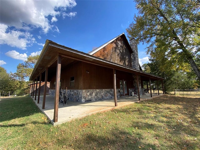 view of side of property featuring a lawn and a patio area