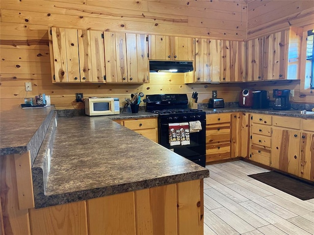 kitchen with wood walls, black electric range oven, and light hardwood / wood-style floors