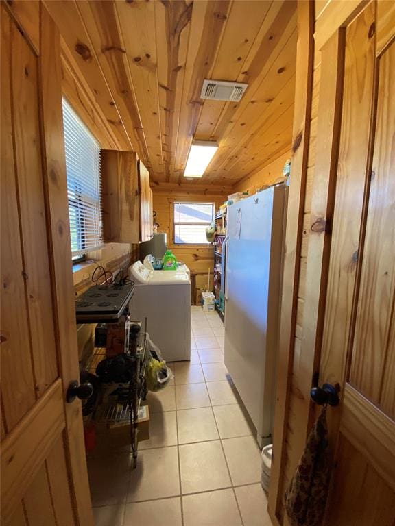 interior space with light tile patterned flooring, wooden ceiling, and washer / dryer