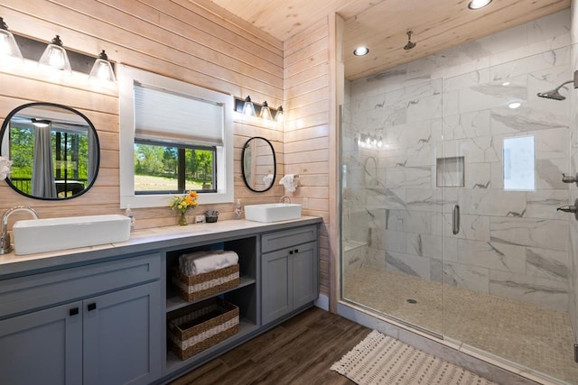 bathroom featuring hardwood / wood-style floors, vanity, wood walls, a shower with door, and wooden ceiling