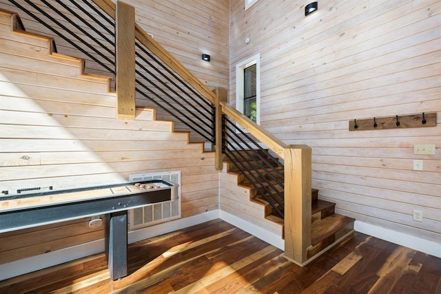 stairs with wooden walls and hardwood / wood-style flooring