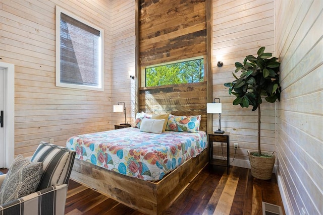 bedroom featuring hardwood / wood-style flooring and wood walls